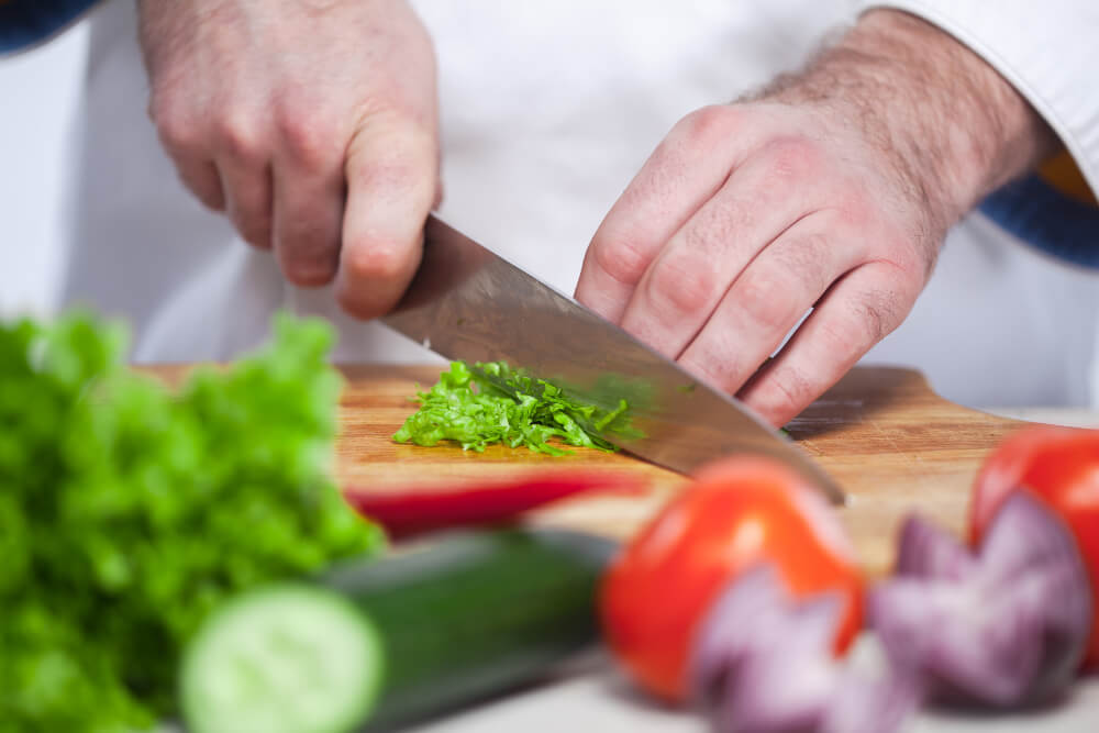 chef cutting green lettuce his kitchen (1)